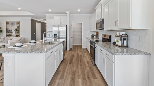 Kitchen island with painted cabinets and stainless steel appliances
