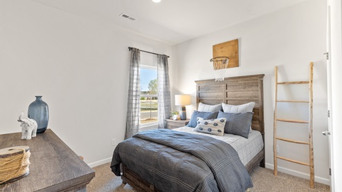 Secondary bedroom with carpet and window