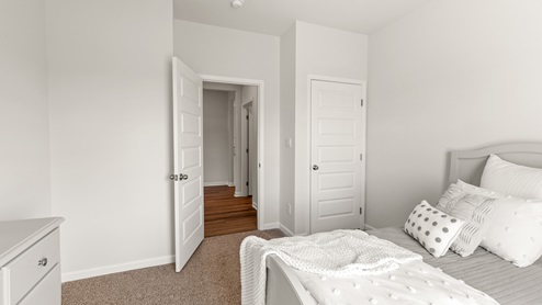 Secondary bedroom with carpet and window