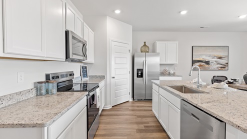 Kitchen island with painted cabinets and stainless steel appliances