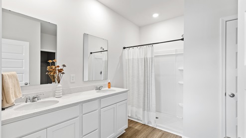 Primary bath with painted cabinets and quartz countertops