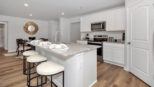 Kitchen island with painted cabinets and stainless steel appliances
