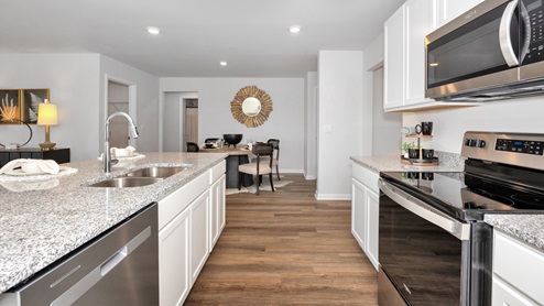 Kitchen island with painted cabinets and stainless steel appliances