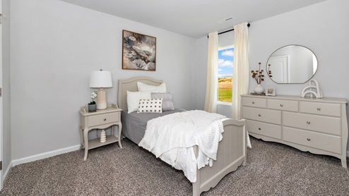 Secondary bedroom with carpet and window