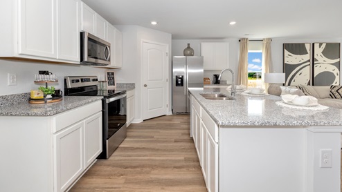 Kitchen island with painted cabinets and stainless steel appliances