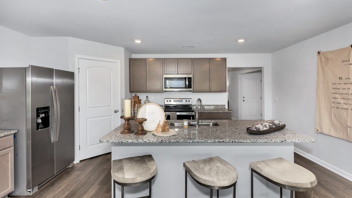 Kitchen island with stained cabinets and stainless steel appliances