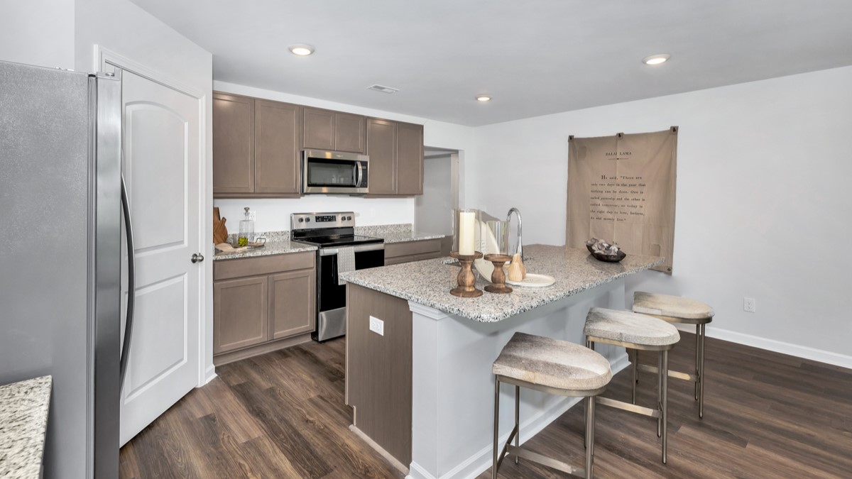 Kitchen island with stained cabinets and stainless steel appliances