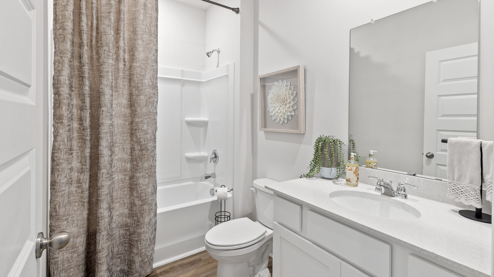 Secondary bathroom with painted cabinets and quartz countertops