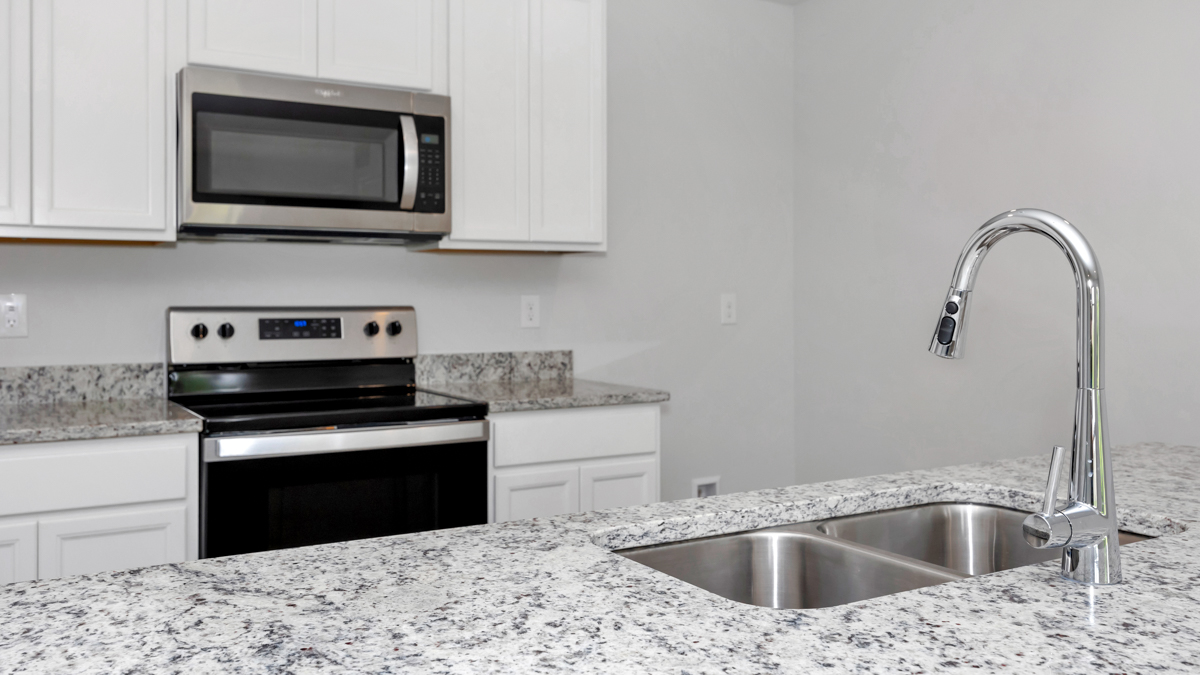 Kitchen sink with granite surround and stainless steel appliances
