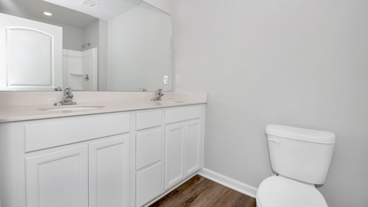 Primary bath with painted cabinets and quartz countertops