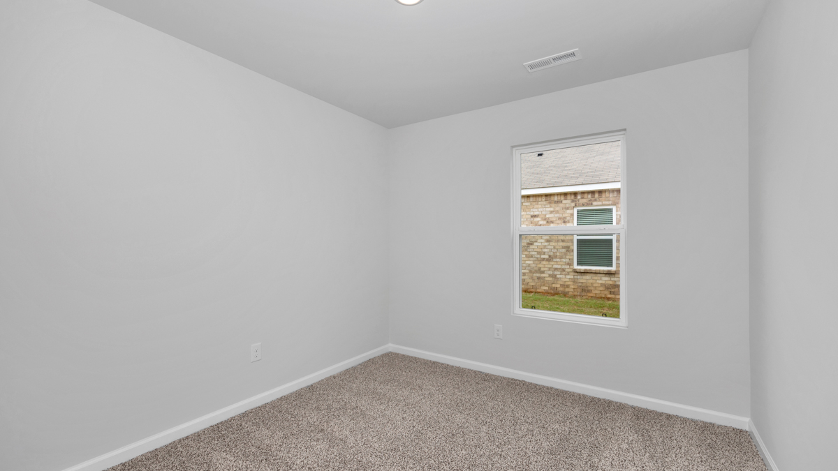 Secondary bedroom with carpet and window