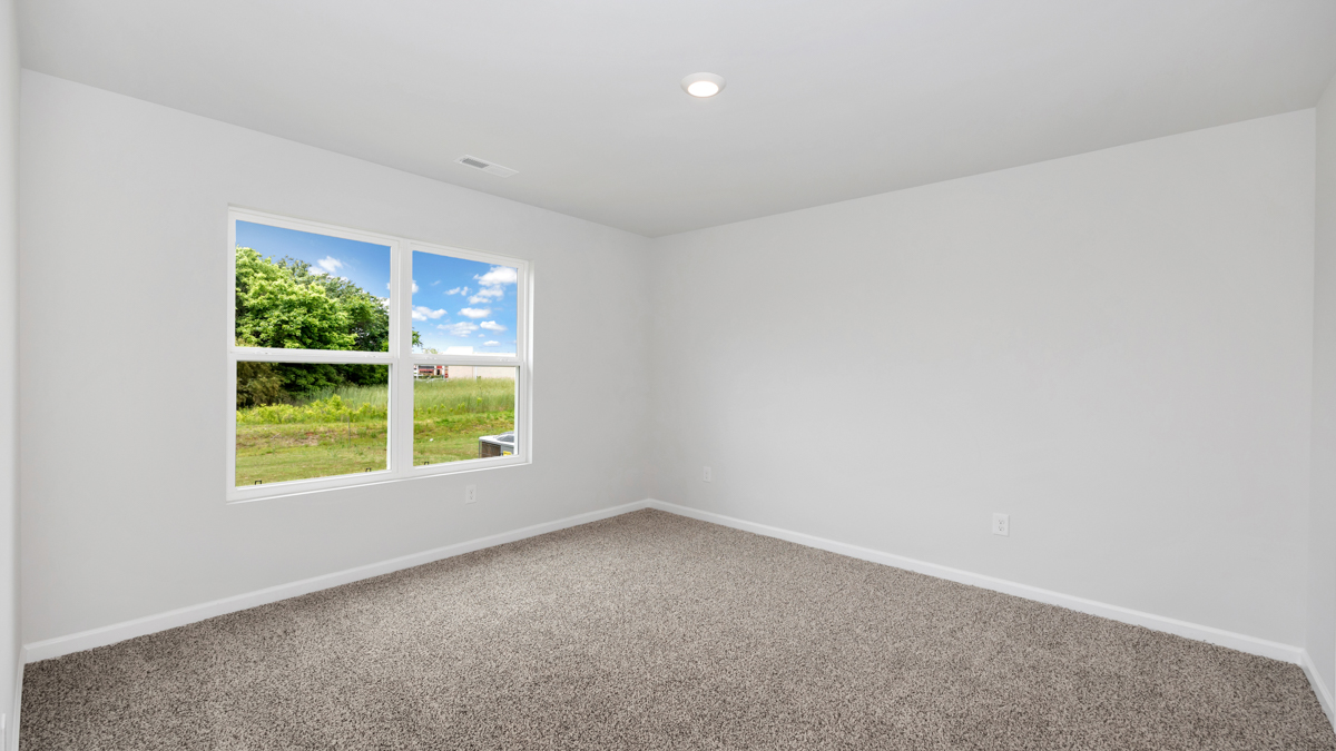 Secondary bedroom with carpet and window