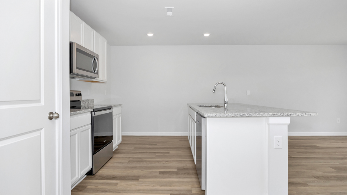 Kitchen island with painted cabinets and stainless steel appliances