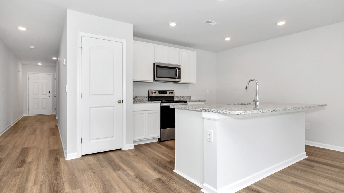 Kitchen island with painted cabinets and stainless steel appliances
