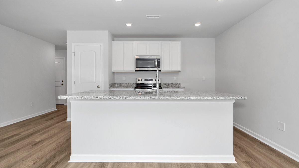 Kitchen island with painted cabinets and stainless steel appliances