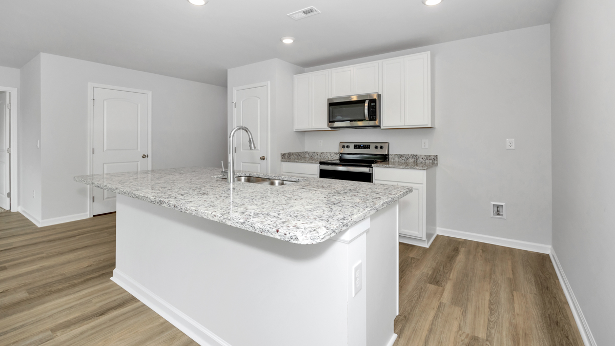 Kitchen island with painted cabinets and stainless steel appliances