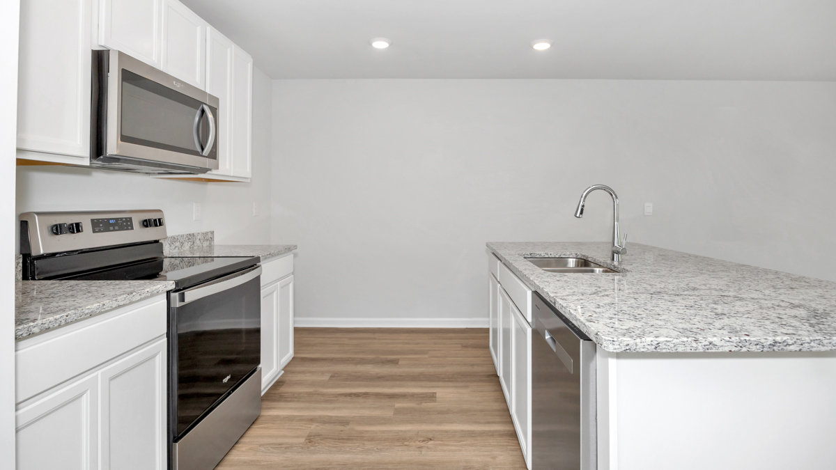 Kitchen island with painted cabinets and stainless steel appliances