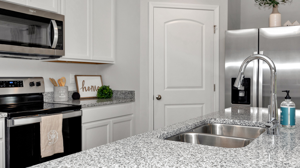 Kitchen sink with granite surround and stainless steel appliances