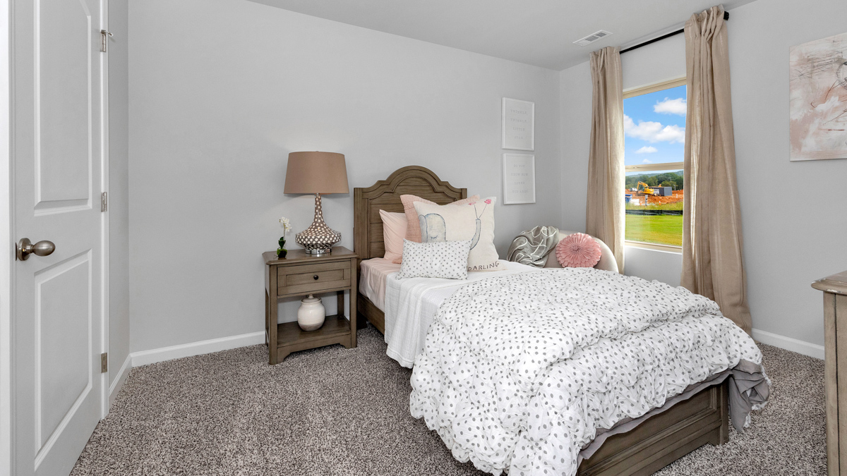 Secondary bedroom with carpet and window