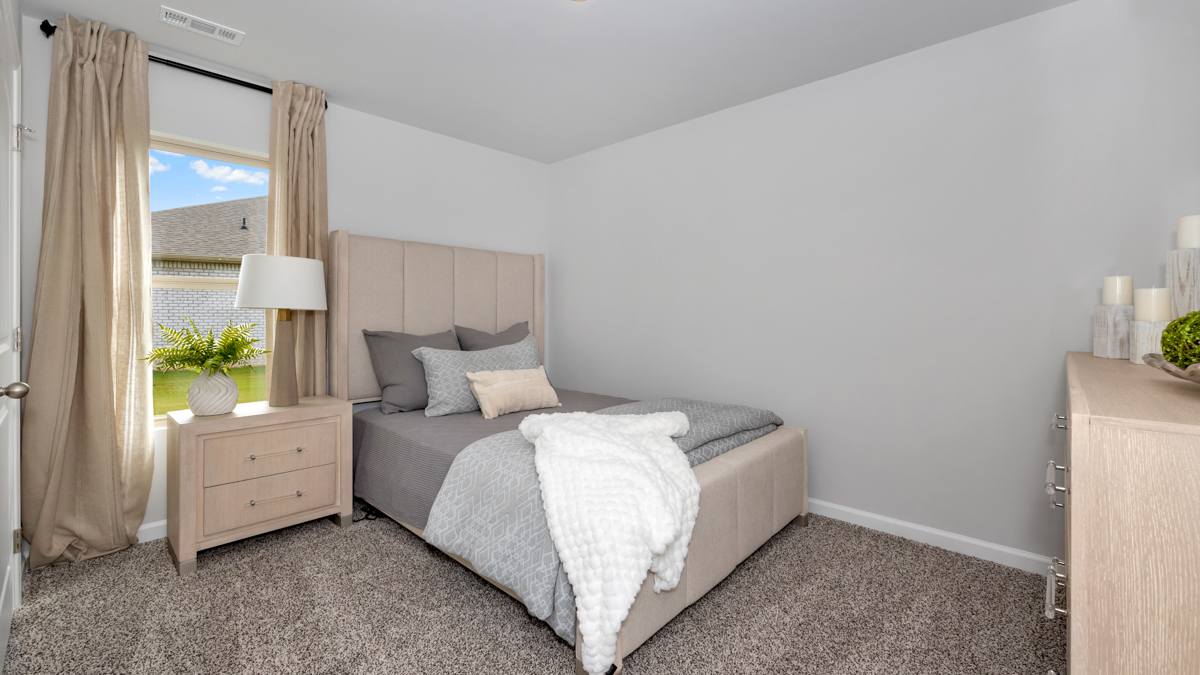 Secondary bedroom with carpet and window