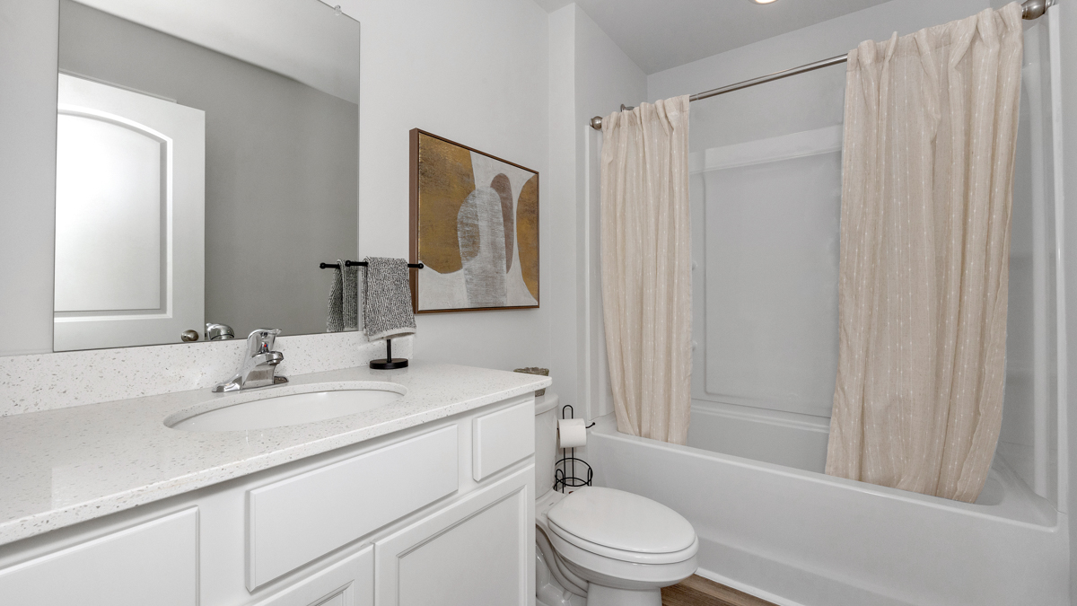 Secondary bathroom with painted cabinets and quartz countertops