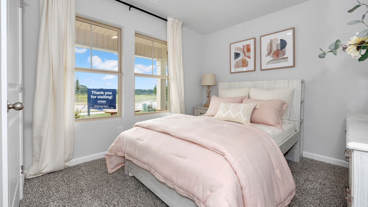 Secondary bedroom with carpet and window