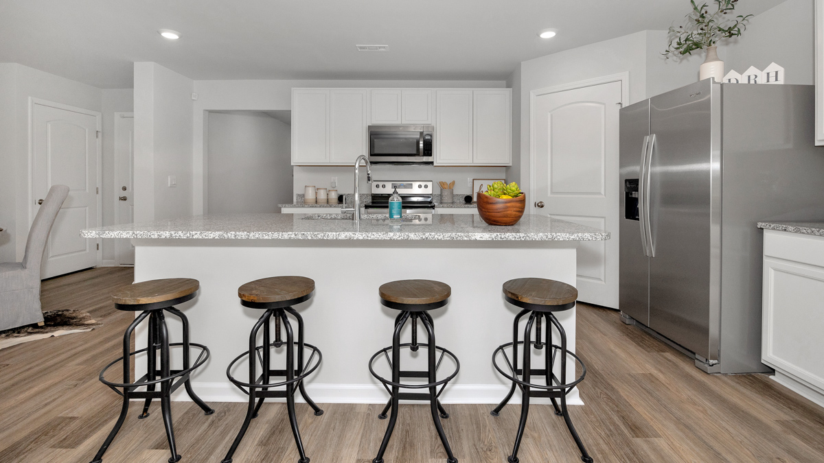 Kitchen island with painted cabinets and stainless steel appliances
