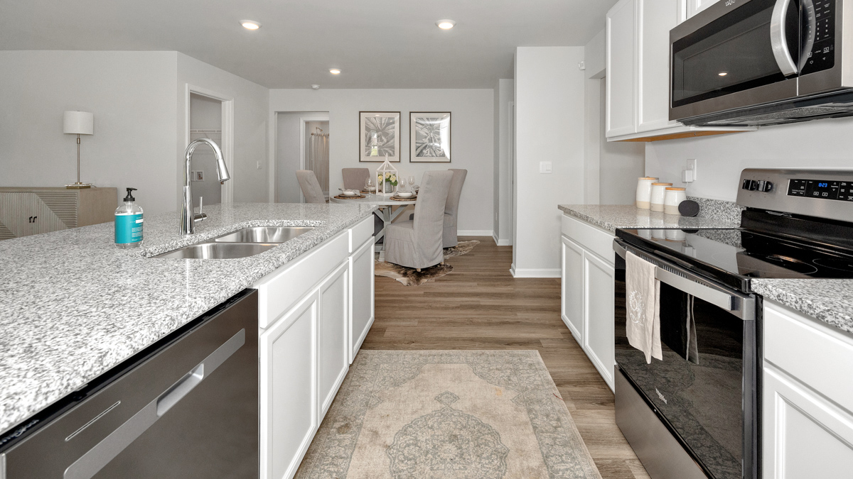 Kitchen island with painted cabinets and stainless steel appliances