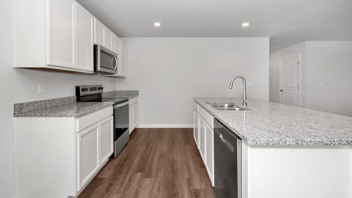 Kitchen island with painted cabinets and stainless steel appliances