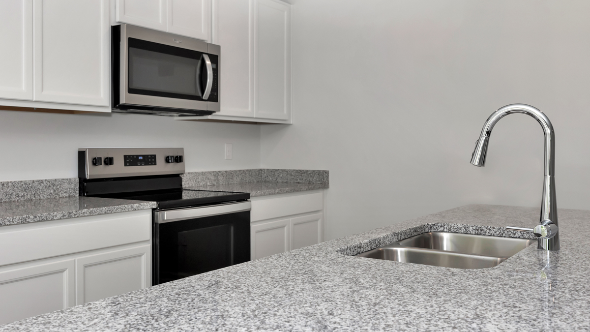 Kitchen sink with granite surround and stainless steel appliances
