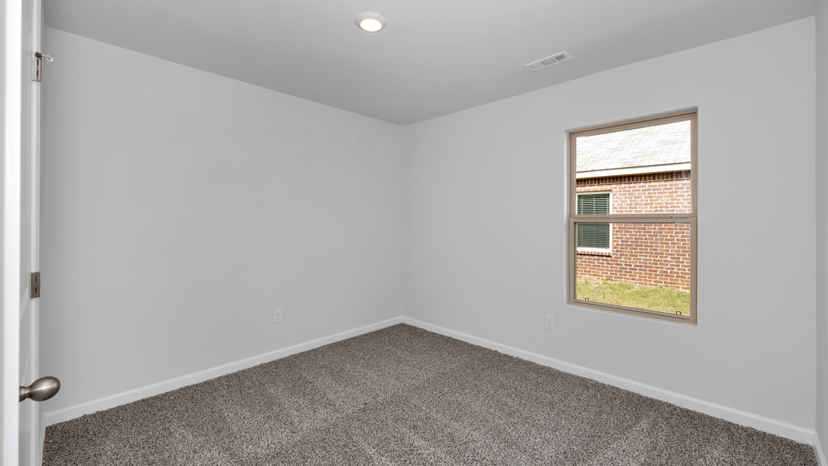 Secondary bedroom with carpet and window