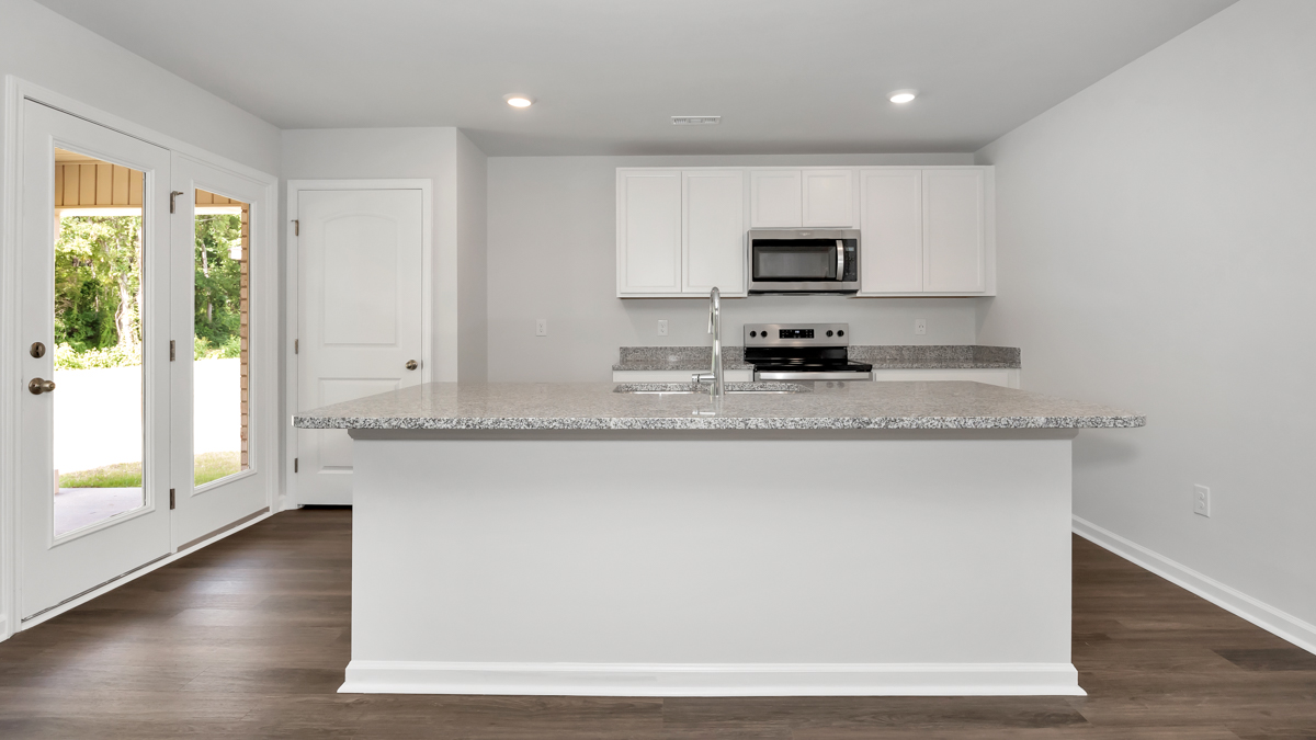 Kitchen island with painted cabinets and stainless steel appliances