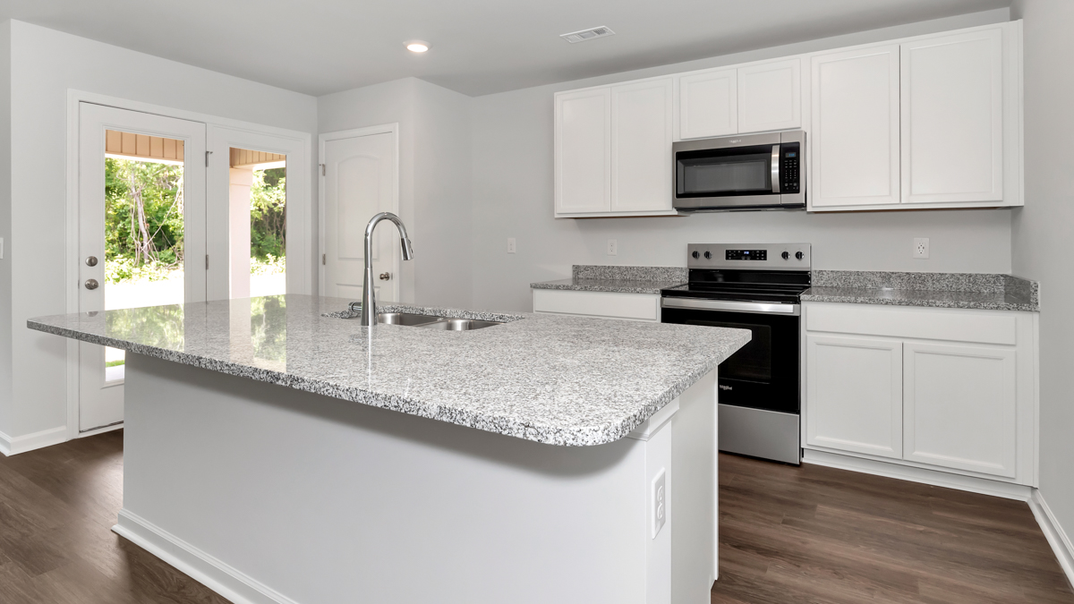 Kitchen island with painted cabinets and stainless steel appliances