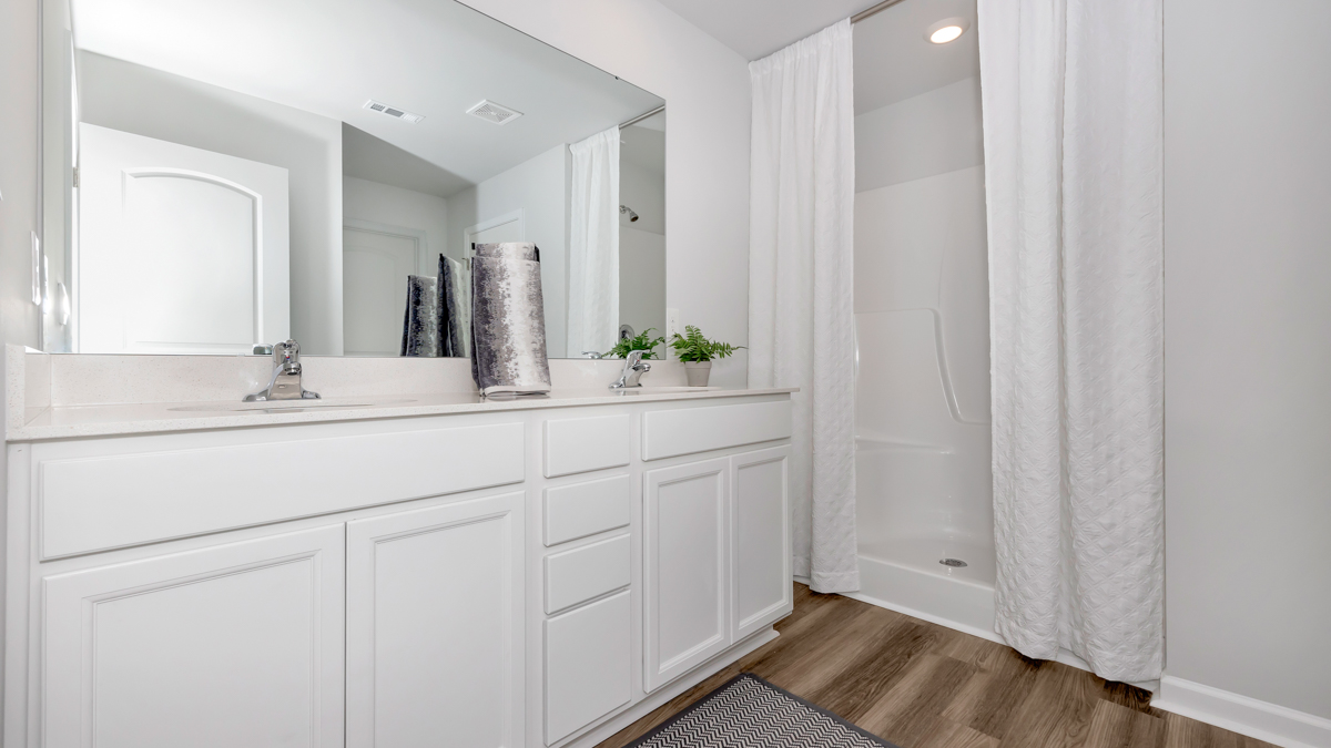 Primary bath with painted cabinets and quartz countertops