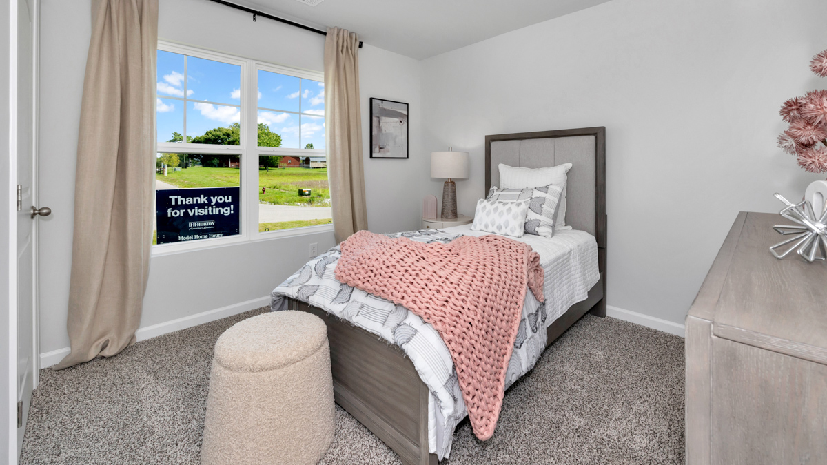 Secondary bedroom with carpet and window