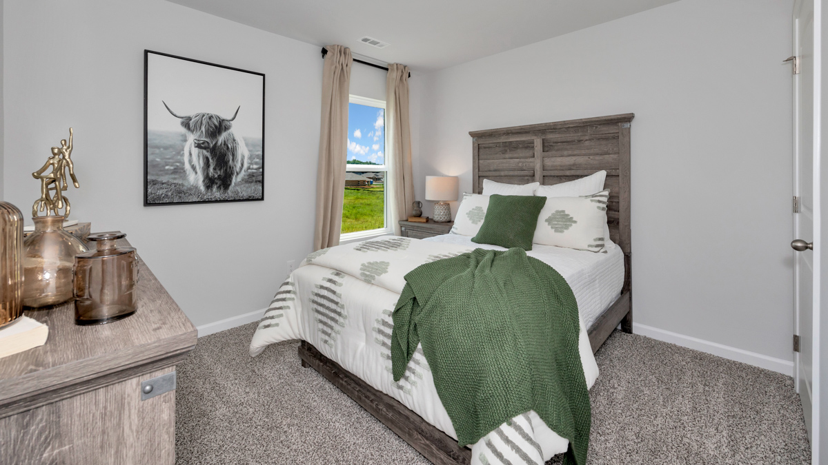 Secondary bedroom with carpet and window
