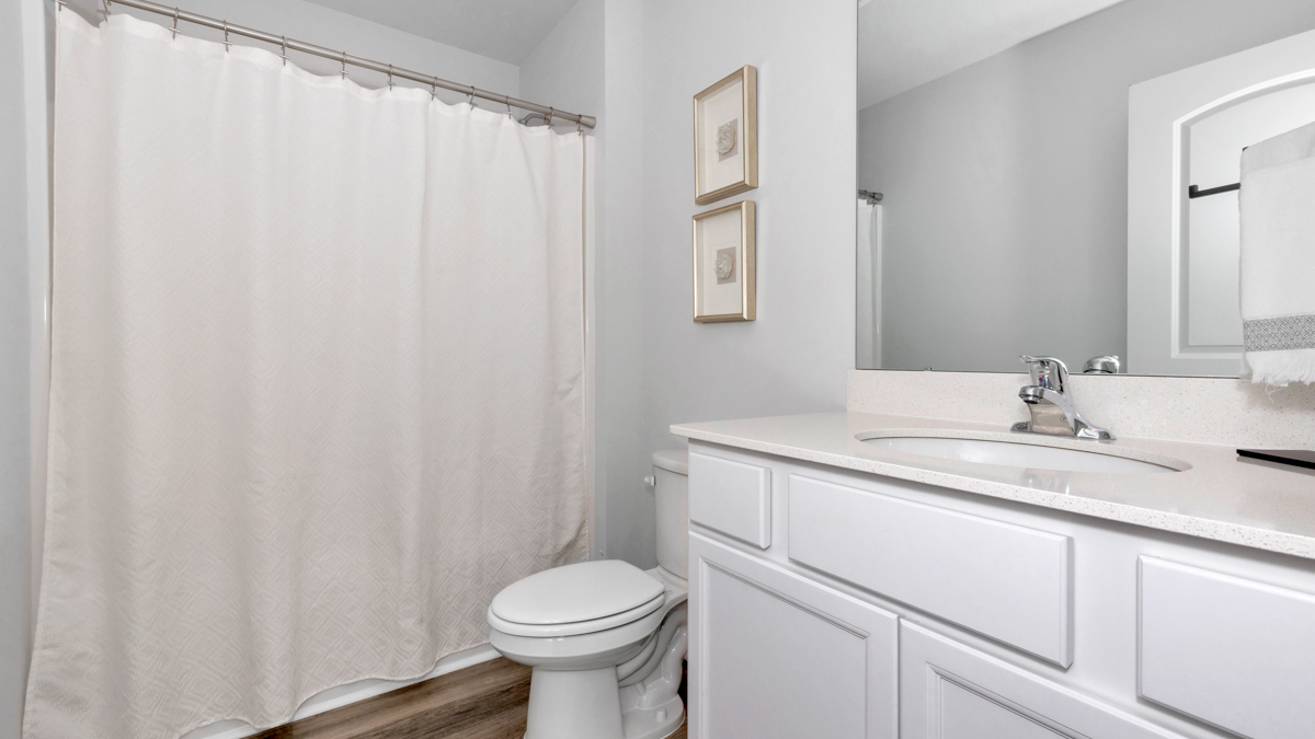 Secondary bathroom with painted cabinets and quartz countertops