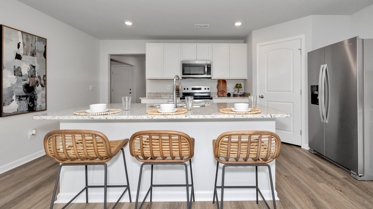 Kitchen island with painted cabinets and stainless steel appliances