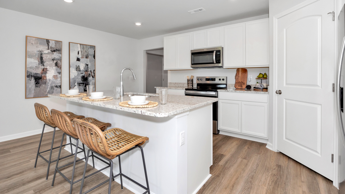 Kitchen island with painted cabinets and stainless steel appliances
