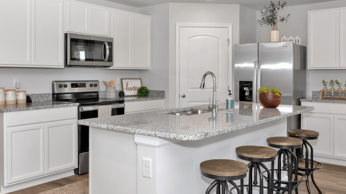 Kitchen island with painted cabinets and stainless steel appliances