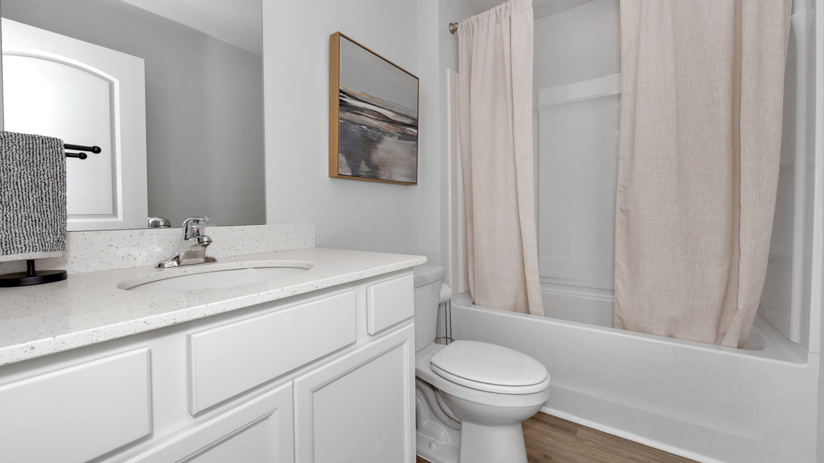 Secondary bathroom with painted cabinets and quartz countertops
