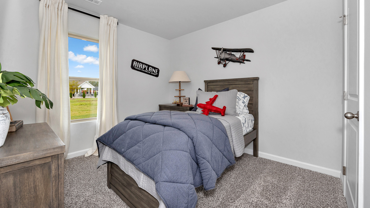 Secondary bedroom with carpet and window