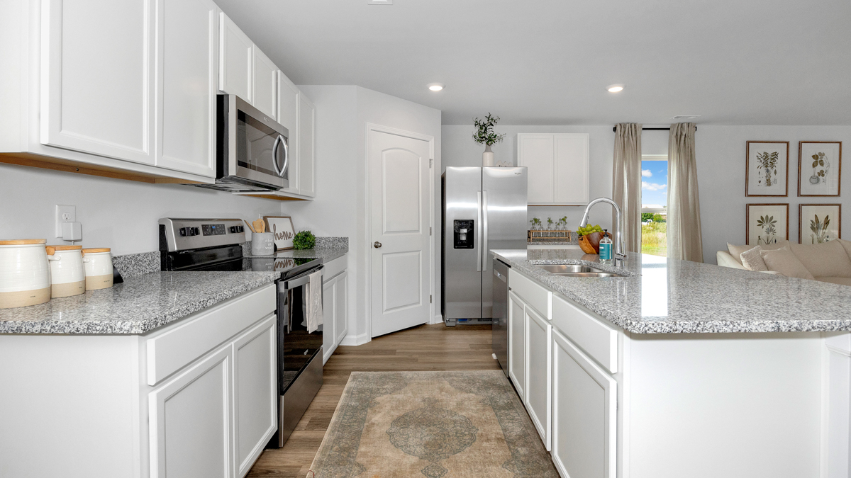 Kitchen island with painted cabinets and stainless steel appliances