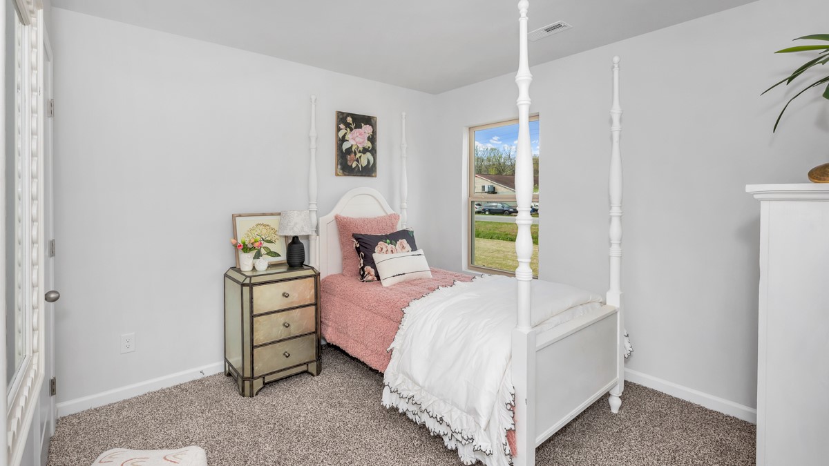 Secondary bedroom with carpet and window