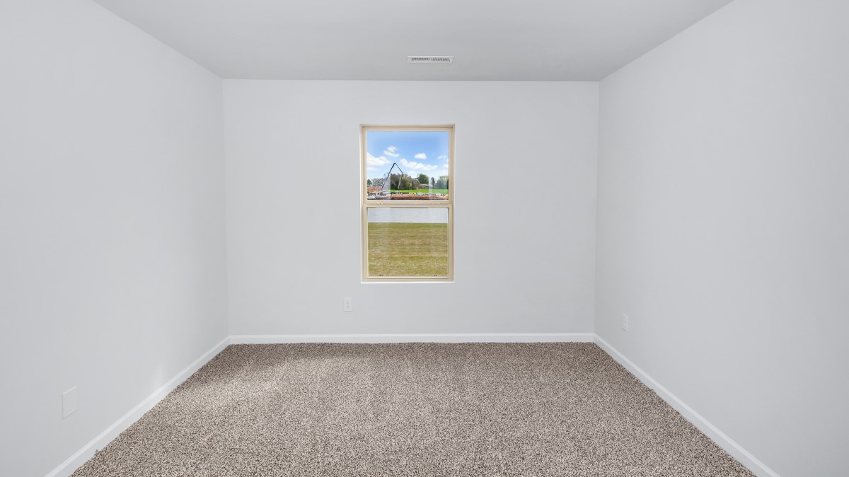 Secondary bedroom with carpet and window