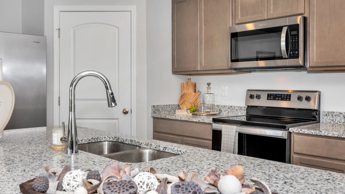 Kitchen sink with granite surround and stainless steel appliances