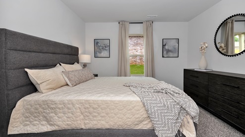 Secondary bedroom with carpet and window
