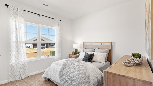 Secondary bedroom with carpet and window
