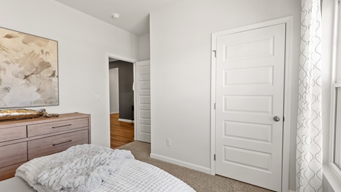 Secondary bedroom with carpet and window