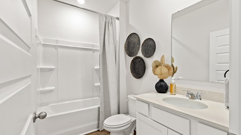 Secondary bathroom with painted cabinets and quartz countertops